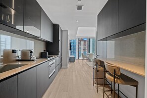 A modern kitchen with a central island, built-in appliances, and a view of high-rise buildings. - 22nd Floor E11EVEN Combined Suite Pool City View (Miami)