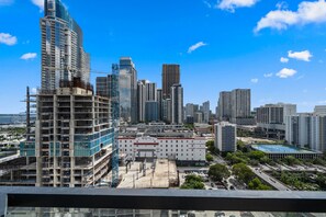 A cityscape with high-rise buildings, a large white building with 'Equinix' signage, and a clear blue sky. - 22nd Floor E11EVEN Combined Suite Pool City View (Miami)