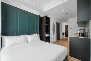 A modern hotel room with a large bed, a built-in wardrobe, a kitchenette, and a bathroom visible through an open door. - Luxury 49th Floor at E11EVEN w/ Rooftop Pool & Gym (Miami)