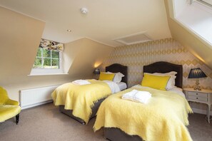 A bedroom with two beds, a window, a radiator, a lamp, and a chair. - Luxury country house with outdoor hot tub overlooking Loch Ard & Ben Lomond (Aberfoyle)
