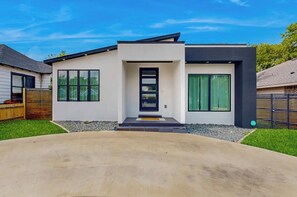 A modern two-story house with a front entrance, a driveway, and a well-maintained lawn. - Modern 3-bedroom house with fabulous Dallas skyline views (Dallas)
