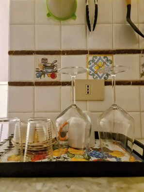 A kitchen counter with a tray holding wine glasses and plastic cups. - Quiet studio in the city center (Palermo)