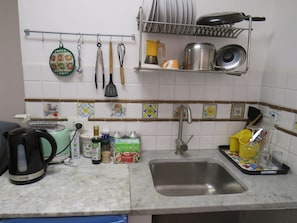 A kitchen with a sink, a toaster, and various kitchen utensils and appliances. - Quiet studio in the city center (Palermo)