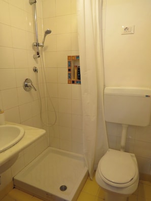 A bathroom with a shower, toilet, and sink. - Quiet studio in the city center (Palermo)