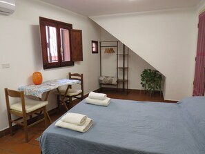 A bedroom with a bed, a desk, a chair, a window, a plant, and a staircase. - Quiet studio in the city center (Palermo)