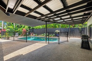 A covered outdoor area with a pool, surrounded by a fence and vegetation. - Serena Oasis Tropical Sanctuary with Private Pool (Nightcliff)