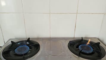 Cozinha com duas bocas de fogão a gás e painel de azulejos.