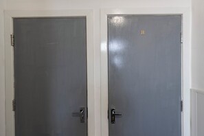 Deux portes fermées, dotées d’une poignée métallique et d’un mécanisme de verrouillage.