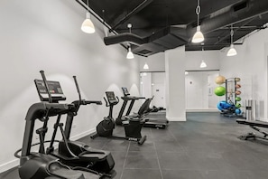 A gym with treadmills, elliptical machines, and a weightlifting area. - Luxury Designer Collection 519 - Fulton Market (Chicago)