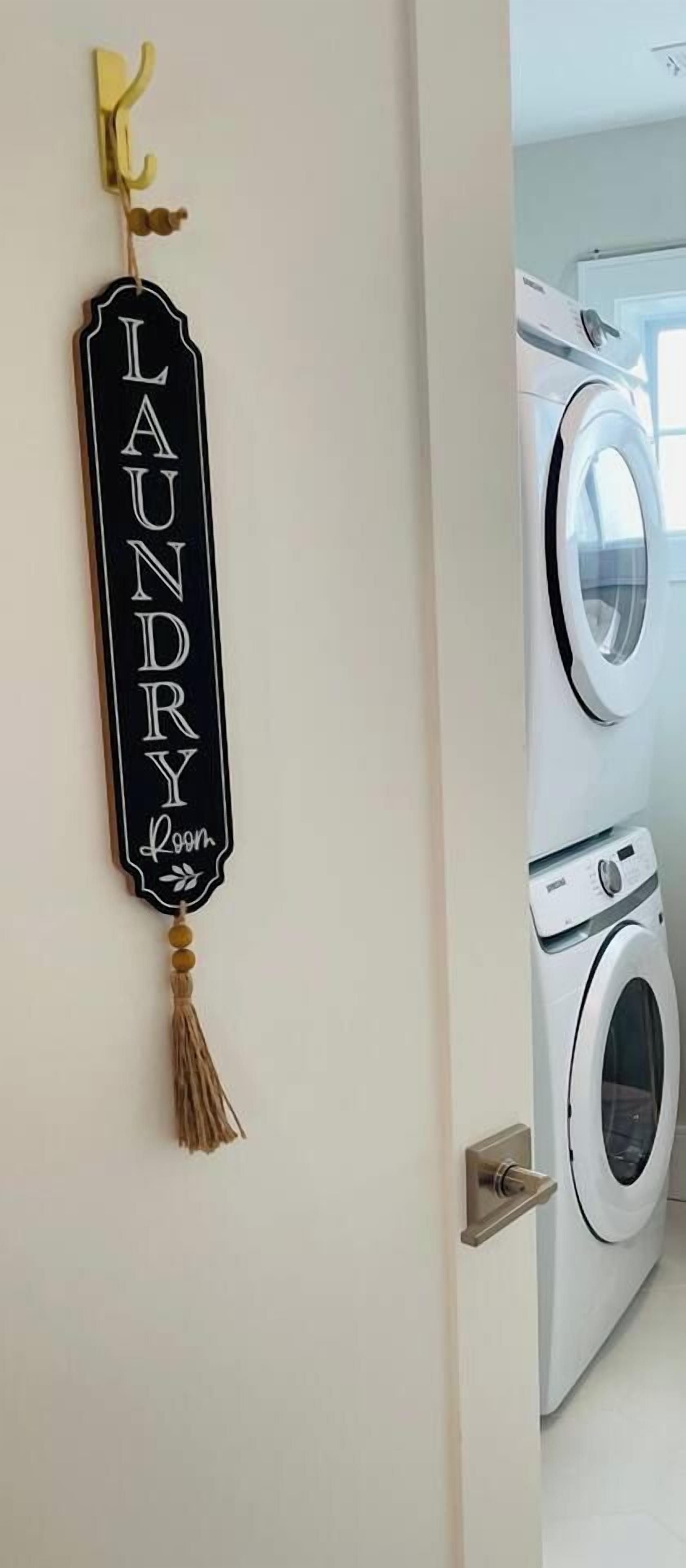 A laundry room with a sign reading 'Laundry Room' and a washing machine.
