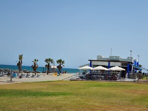 A beachside restaurant with outdoor seating and a view of the sea. - Vacation Apartment – Pool, Terrace, and Nearby Beach (Roquetas de Mar)