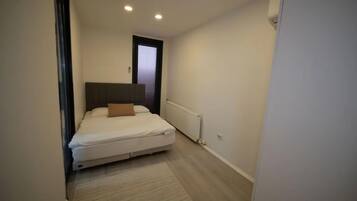 Un dormitorio con cama, ventana y radiador.