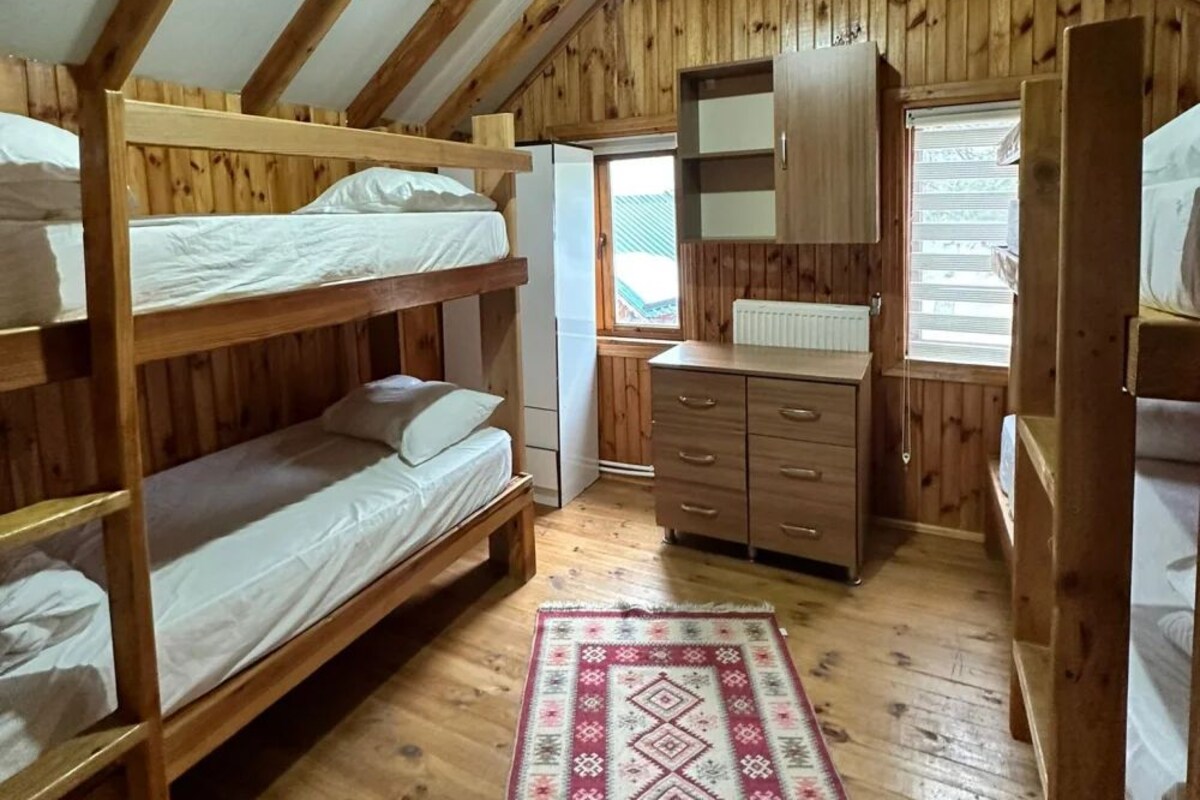 Een kamer met houten stapelbedden, een dressoir en een radiator.