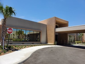 A modern building with a 'DO NOT ENTER' sign, large windows, and a paved entrance area with landscaping. - Luxury 3BR Villa w/ BBQ Near Disney (Kissimmee)