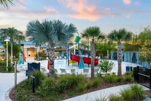 Ein Wasserpark mit Pool, Rutschen und Palmen.