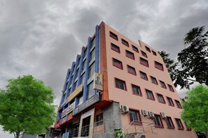 A multi-story building with commercial signage, including a bank and a gold loan advertisement. - Hotel O K N Residency (Bengaluru)