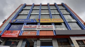 A multi-story building with various commercial establishments on the ground floor, including a bank and a gold loan company.