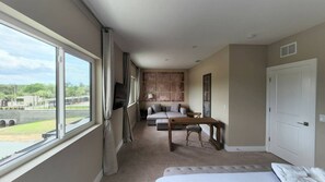 A hotel room with a large window, a sofa, a table, and a bed. - 3053 Magic Village Exceptional Jacuzzi 8min Disney (Kissimmee)