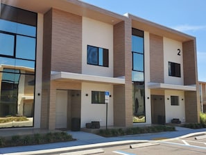 A modern multi-story building with a flat roof, large windows, and a number '2' sign. - 3053 Magic Village Exceptional Jacuzzi 8min Disney (Kissimmee)
