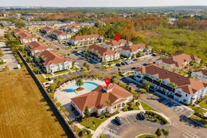 A residential area with detached houses, a swimming pool, and a parking lot. - 12 min to Disney 3BR Home w/ Resort Access (Kissimmee)
