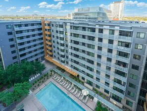A multi-story hotel with a rooftop pool, outdoor seating, and a view of the cityscape. - Chic 2BR | Pool | W/D | Wi-Fi Near Arts District (Phoenix)
