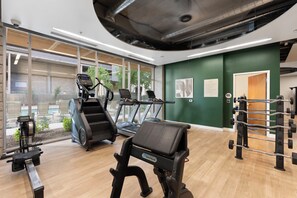 A gym with treadmills, a rowing machine, and weightlifting equipment. - Chic 2BR | Pool | W/D | Wi-Fi Near Arts District (Phoenix)