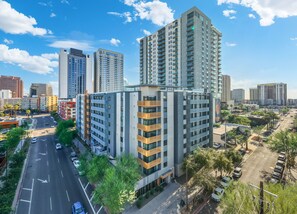 A modern high-rise building with multiple floors, surrounded by a cityscape. - Chic 2BR | Pool | W/D | Wi-Fi Near Arts District (Phoenix)