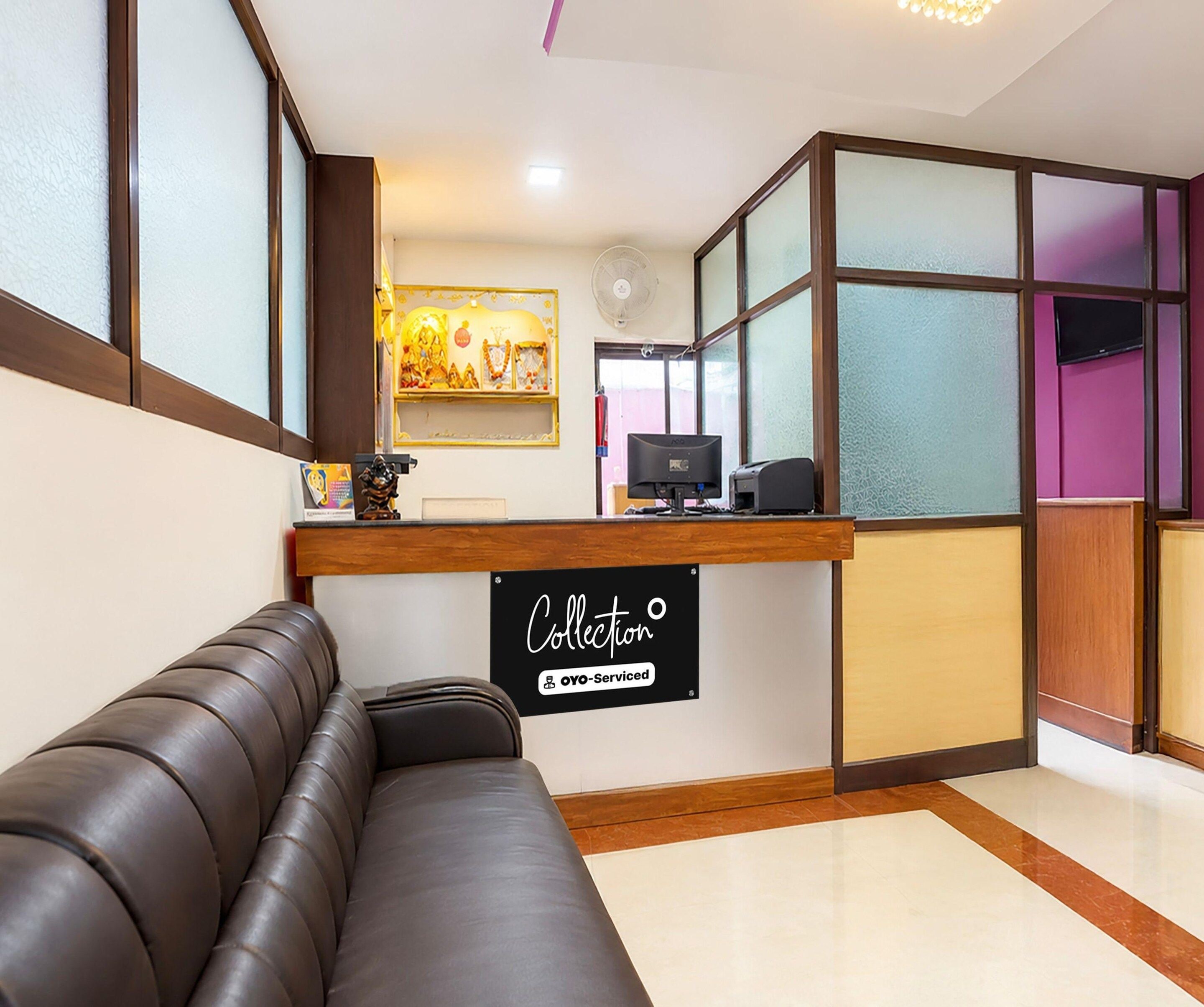 A reception area with a leather sofa, a sign reading 'Collection OYO-Serviced', and a computer monitor.