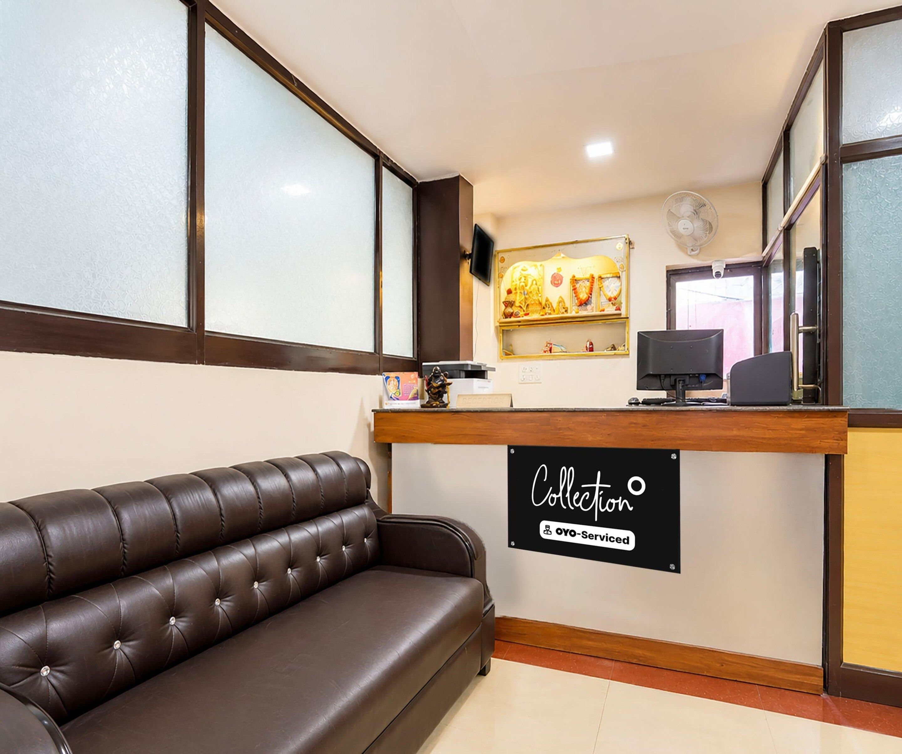 A reception area with a leather sofa, a reception desk, a computer, and a sign indicating 'Collection' and 'Ovo-Serviced'.