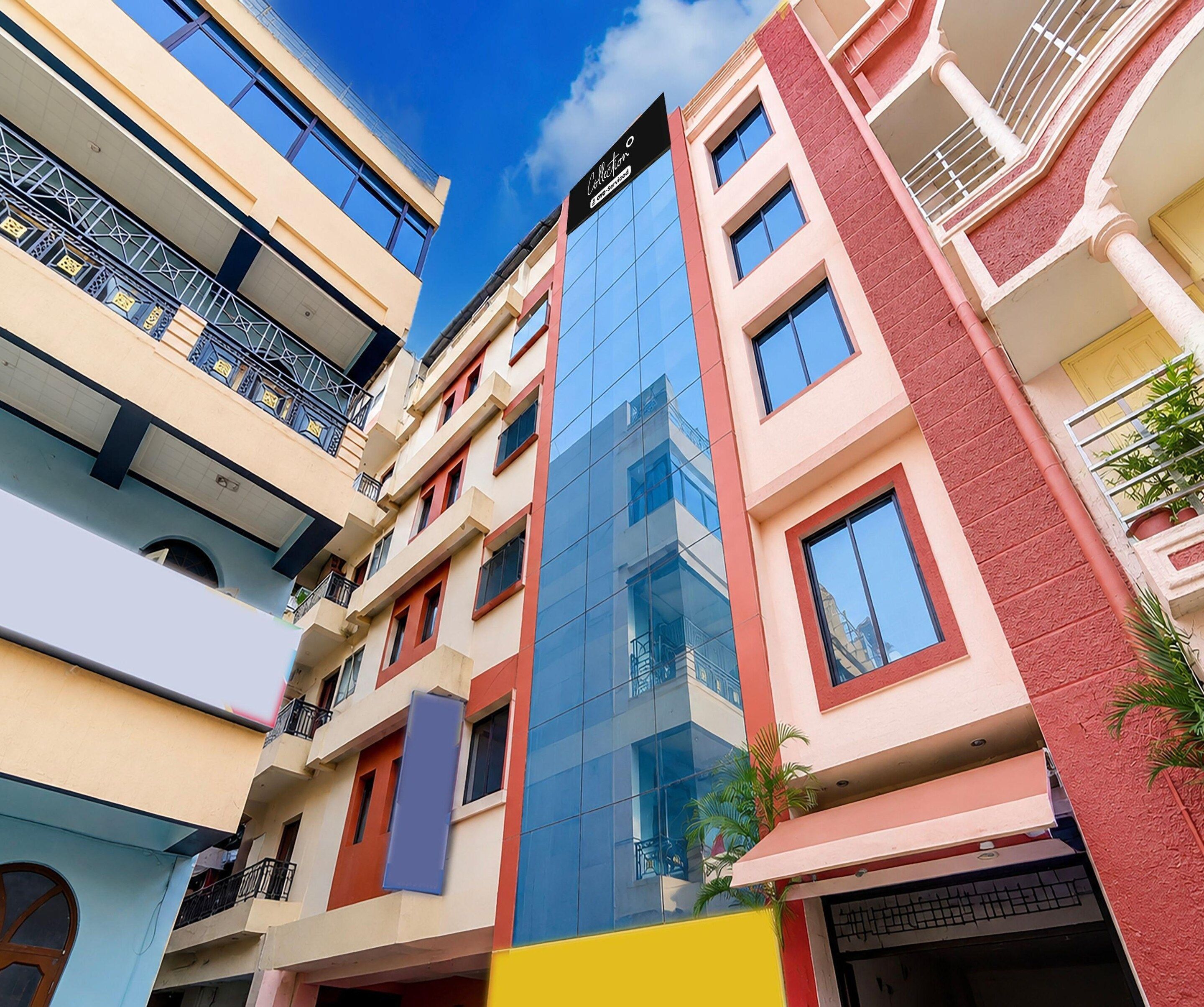 A multi-story building with balconies, large windows, and a clear sky.