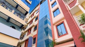 A multi-story building with balconies, large windows, and a clear sky.
