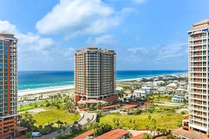 A high-rise hotel with a central courtyard, beachfront view, and a pool area. - Portofino Island Resort 2-1508 (Pensacola Beach)