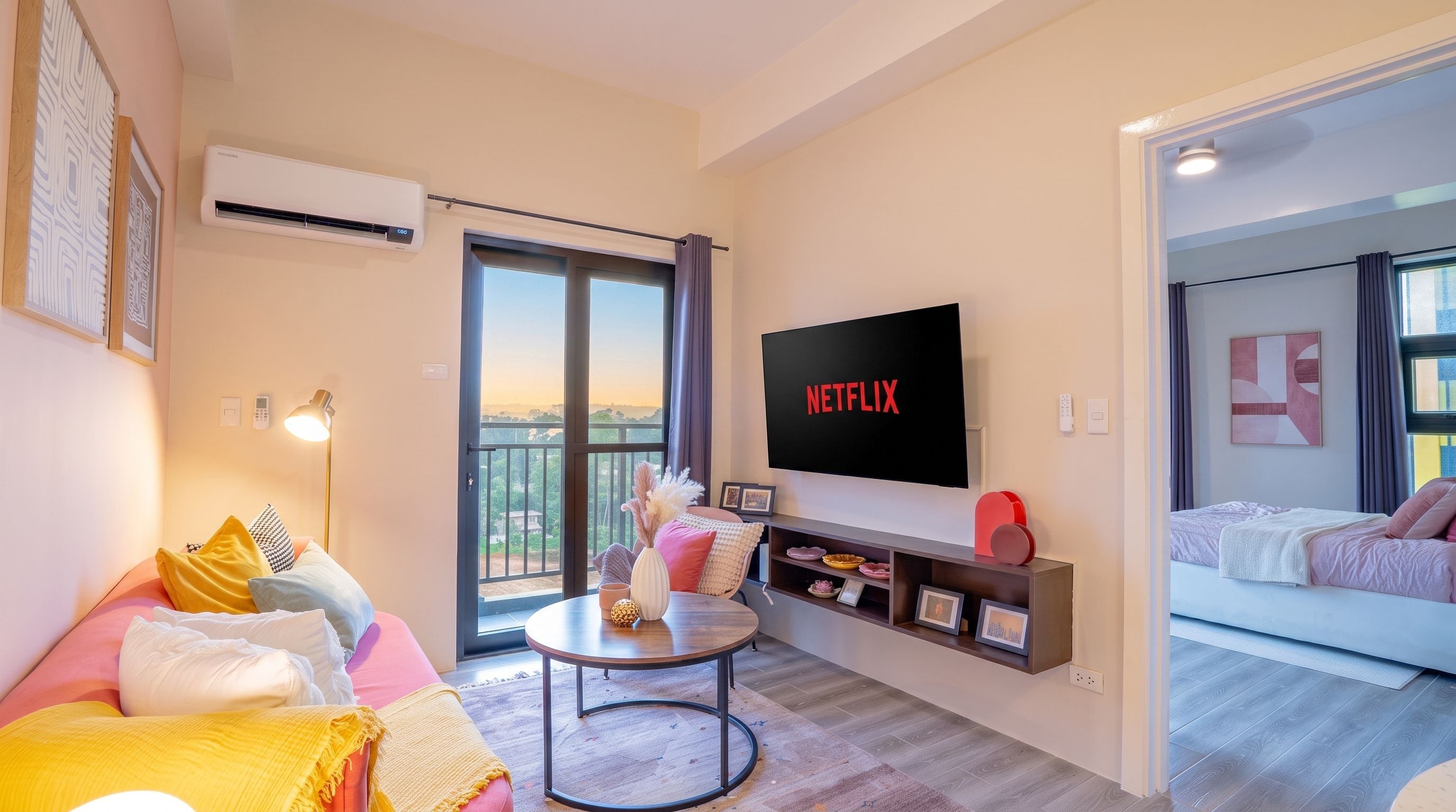 Un salon moderne doté d’un téléviseur à écran plat, d’un canapé, d’une table basse et d’un balcon offrant une vue agréable.