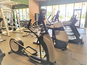 A gym with various exercise equipment including treadmills, elliptical machines, and weight machines. - 6 min to Disney - Modern 4suite Home (Kissimmee)