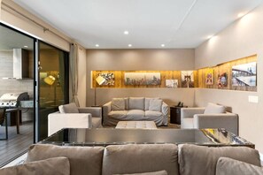 A modern living room with a sofa set, a glass coffee table, and a cityscape artwork on the wall. - Magic Village 3 Suites Jacuzzi 6min Disney (Kissimmee)