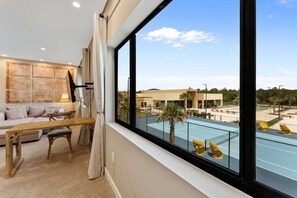 A hotel room with a large window overlooking a pool area. - Magic Village 3BR w/ Jacuzzi & BBQ Near Disney (Kissimmee)
