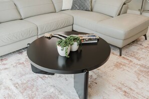 A round black coffee table with two white pots containing green plants and a string of beads. - Storey Lake 4BR Villa With Pool and Disney Rooms (Kissimmee)