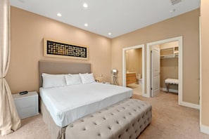 A bedroom with a large bed, bedside tables, a bedside lamp, a wall-mounted artwork, and an open closet leading to a bathroom. - Magic Views Excellent 4suites Near 192/disney (Kissimmee)
