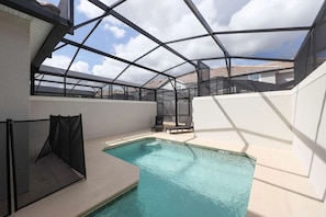 An indoor swimming pool with a glass ceiling, surrounded by walls and a few lounge chairs. - 4BR Townhome Private Pool 10 min to Disney (Kissimmee)