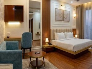 A hotel room with a bed, a desk, a chair, and a television. - Deluxe 66 Inn Guest House (Bidhannagar)