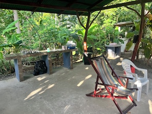 An outdoor seating area with a table and chairs, surrounded by lush greenery. - Cozy 2-bedroom cabin in nature full Puerto Viejo, Limon, Costa Rica (Limón)