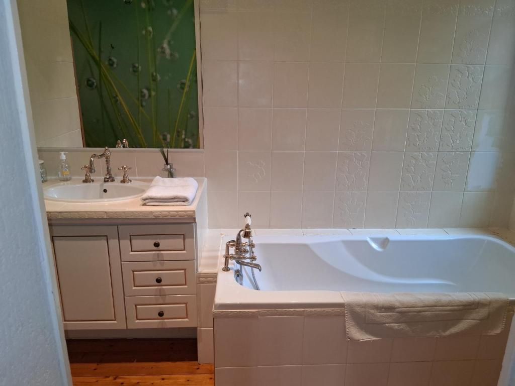 Een badkamer met een bad, een wastafel en een spiegel.