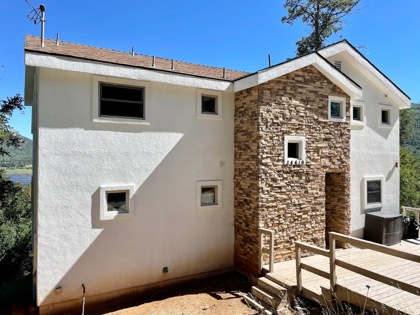A two-story building with a stone facade and a white exterior.