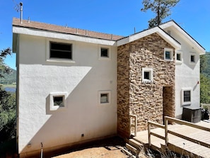 Un edificio de dos pisos con fachada de piedra y exterior blanco.