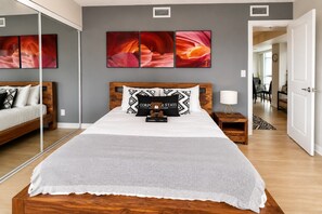 A modern bedroom with a wooden bed, grey walls, and a large mirror. - Downtown Toronto 1-Bedroom Apartment | Motion (Toronto)