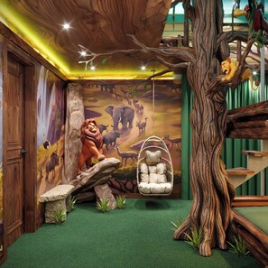 A room with a mural of a savannah scene, a hanging chair, and a tree trunk structure. - 15BR house sleeps 15 with spa and pool table (Kissimmee)