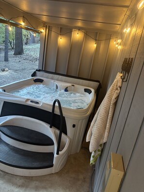 A hot tub with a pump, surrounded by wooden walls and string lights. - Sleeps 12 | 3 Baths | Hot Tub | Near Bear Valley (Arnold)