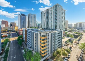 A high-rise building with multiple floors, surrounded by other buildings, a parking lot, and a clear sky. - Sleek 2BR | Pool | W/D | Wi-Fi Near Arts District (Phoenix)