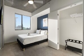 Ein Schlafzimmer mit einem Bett, einem Fenster, einem Deckenventilator und einer Tür.