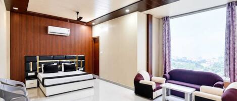A modern living room with a bed, sofa, and a ceiling fan.